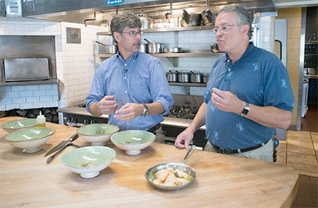 Watts, right, tastes his shrimp as prepared by Chef Hastings at Hot and Hot Fish Club