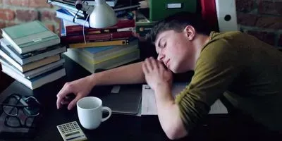 student sleeping at a desk illustrating the challenge of How to Stay Awake (Without Caffeine)