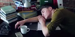 student sleeping at a desk illustrating the challenge of How to Stay Awake (Without Caffeine)