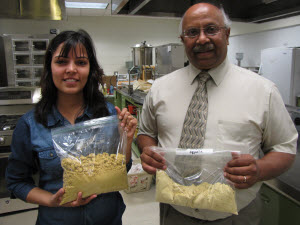 Jigyasha Mishra holds a bag of semi-processed dried distiller's grain and Padu Krishnan, right, holds a bag of food-grade DDG