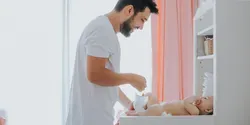 father changing baby's diaper