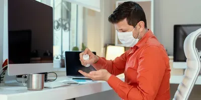 guy wearing a mask and sanitizing his hands to prevent COVID-19 virus transmission