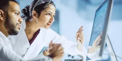 Two researchers looking at a monitor