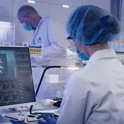 Researchers wearing PPE doing research on coronavirus on computers