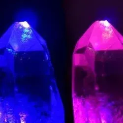 Image of quartz crystals under illumination with strong laser fields of different coloured light (red and blue), and both colours added together (middle).