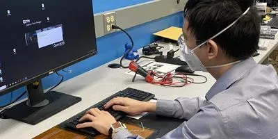Sunghoon Ivan Lee demonstrates how the wearable device is charged through his left forearm's contact with the power transmitter below the keyboard.