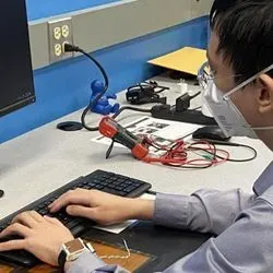 Sunghoon Ivan Lee demonstrates how the wearable device is charged through his left forearm's contact with the power transmitter below the keyboard.