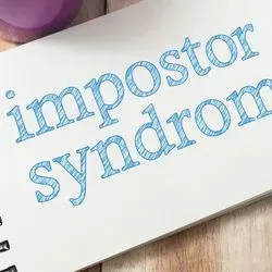 Note pad with the words imposter syndrome written on it