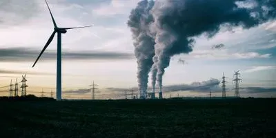 Windmill next to smoke stack