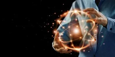 Abstract image of researcher holding an atom made of light