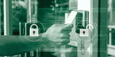 An closeup on someone's arm and hand using a key card to get through a locked door with a keypad. The image is in green tones and there is an overlay of a closed lock graphic and an open lock graphic.