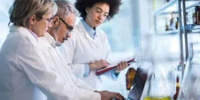 Scientists looking at a laptop in the lab