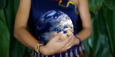 Woman holding a globe to her stomach