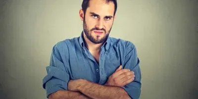 Angry man with arms crossed looking at camera