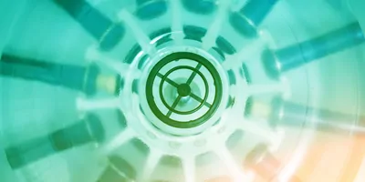 A closeup image of blurred tubes spinning in a centrifuge. The image is green in color.