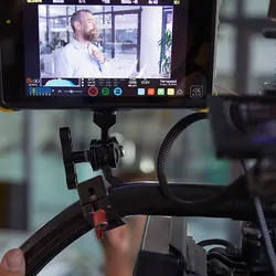 Man preparing for a filmed interview seen from behind the camera