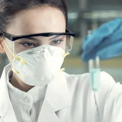 Female researcher in a face mask examining a sample