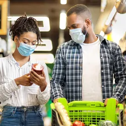 Man and women grocery shopping with masks on