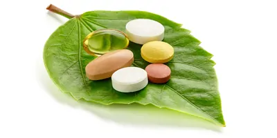 Pills on a leaf on a white background