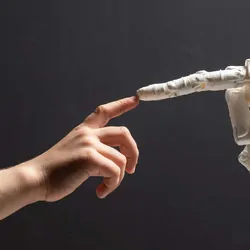 Human hand reaching out to touch fingers with a robot hand
