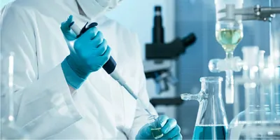 A scientist in a lab holding a pipette