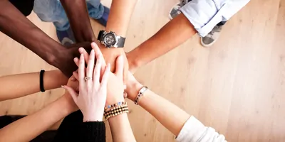 A team puting their hands together, shot from above