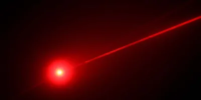 A red light laser on a black backdrop