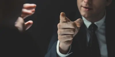Man in suit pointing finger aggressively at someone
