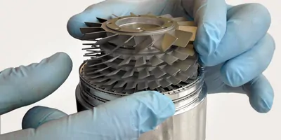 Rotor and stator of a vacuum pump being handled with nitrile gloves.