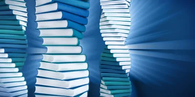 Books pilled into a helix like shape on a blue background