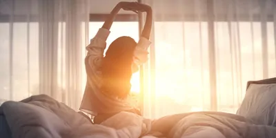 Women, waking up and stretching in the morning light