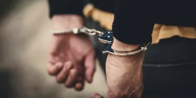 Person with hands cuffed behind their back