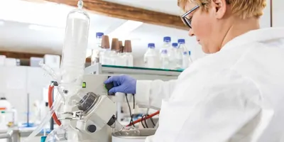 A female scientist in the lab working with a microscope.