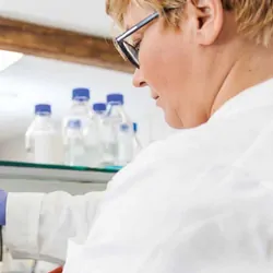 A female scientist in the lab working with a microscope.