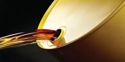 Close up shot of oil pouring out of yellow barrel.