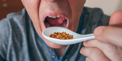 Man eating spoonful of mealworms