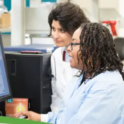 A photo of a group of scientist working with microplate technology in a lab