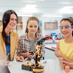 High school students working with the teacher, learning about robotics