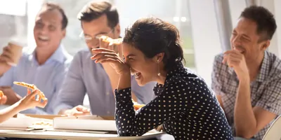 Group of coworkers laughing during a lunch break