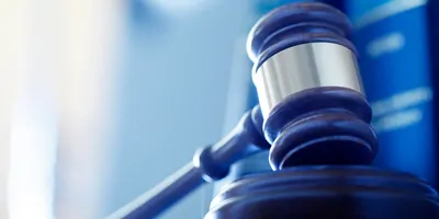A gavel resting on a desk, blue tinted