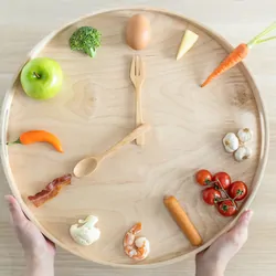 Clock made out of food, on a wooden table emphasizing that time of day eating is important for heart heath and diabtes management