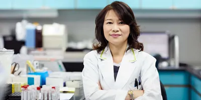 Female researcher with arms crossed looking at the camera