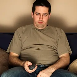 Person sitting on couch watching TV looking bored a typcal hobby that is considered a favorite of boring people