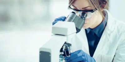 Young scientist looking through a microscope in a laboratory