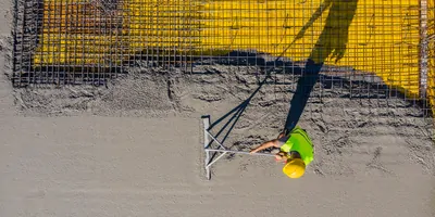 Construction worker laying down cement
