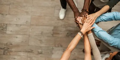 Team members putting their hands together