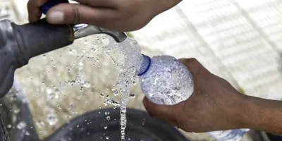 PErson filling a bottle up with fresh water
