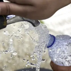 PErson filling a bottle up with fresh water