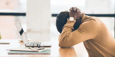 lack businessman feeling upset and desperate, working at office, hands on head. Free space