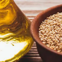 a glass container of oil and a bowl of grains that can be tested and analyzed 